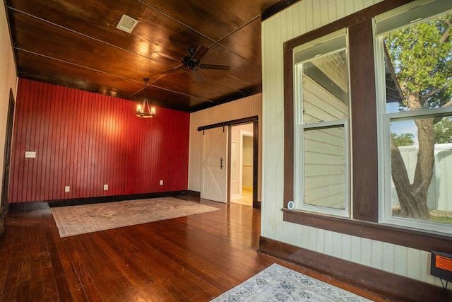 2950 Ranch Road 33, Big Spring, TX 79720 - unfurnished room featuring a barn door, hardwood / wood-style flooring, wooden ceiling, wooden walls, and plenty of natural light