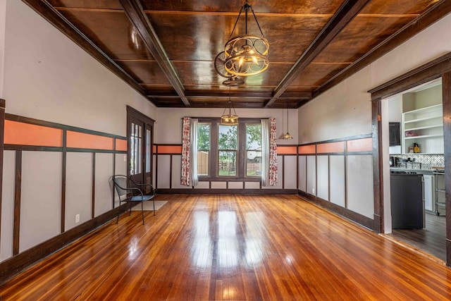 2950 Ranch Road 33, Big Spring, TX 79720 - empty room featuring hardwood / wood-style floors, a chandelier, a wood ceiling with exposed beams, a wainscoted wall, and a decorative wall