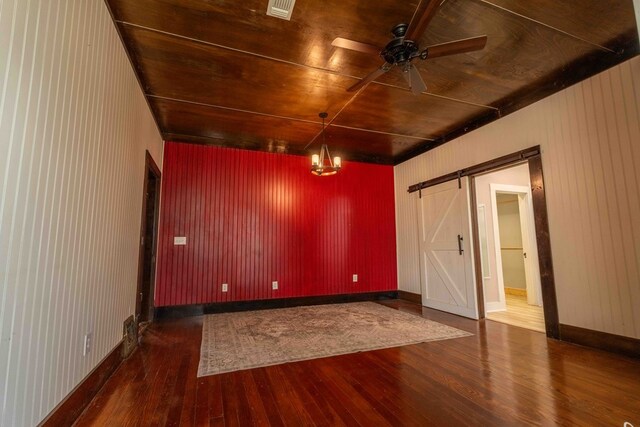 2950 Ranch Road 33, Big Spring, TX 79720 - empty room with hardwood / wood-style flooring, a barn door, ceiling fan, and a chandelier
