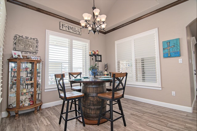 dining room with light wood finished floors, baseboards, crown molding, and an inviting chandelier