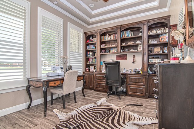 office space featuring crown molding, light wood-style flooring, a ceiling fan, and baseboards