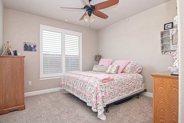 carpeted bedroom featuring baseboards and ceiling fan