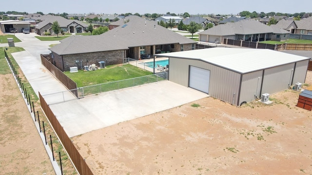 exterior space featuring an outdoor structure, fence, a residential view, and driveway