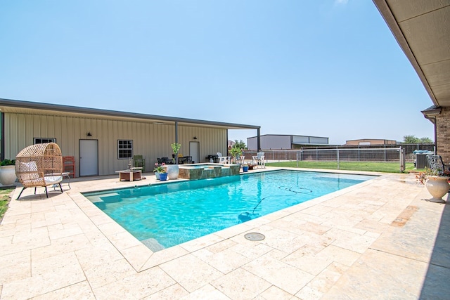 view of swimming pool with a patio area, fence, and a pool with connected hot tub