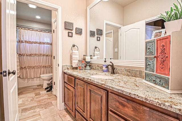 full bathroom with vanity, toilet, and stone finish flooring