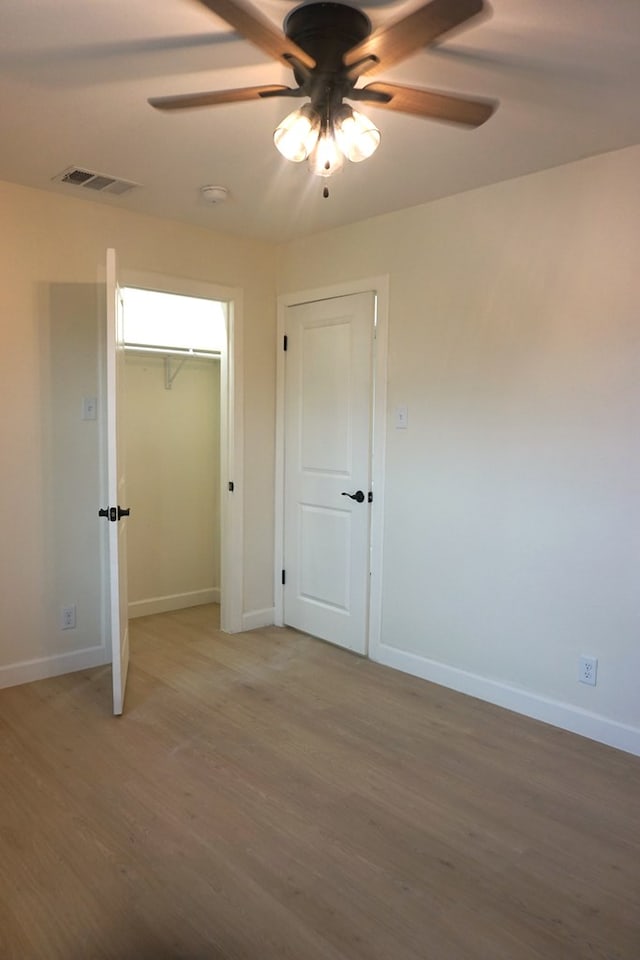 unfurnished bedroom featuring wood-type flooring and ceiling fan