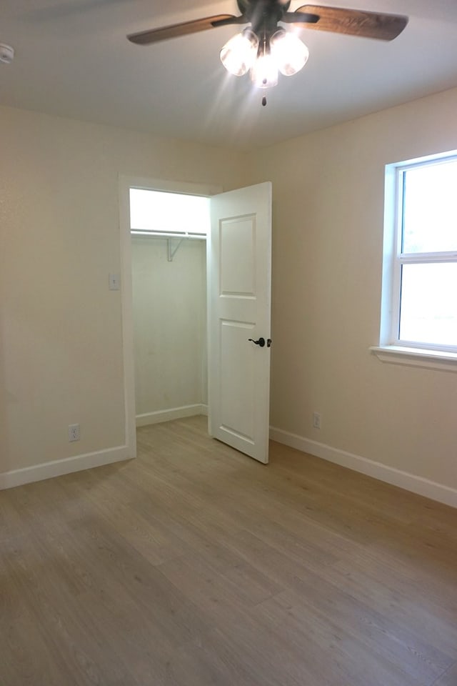 unfurnished bedroom with ceiling fan, a closet, and light hardwood / wood-style floors