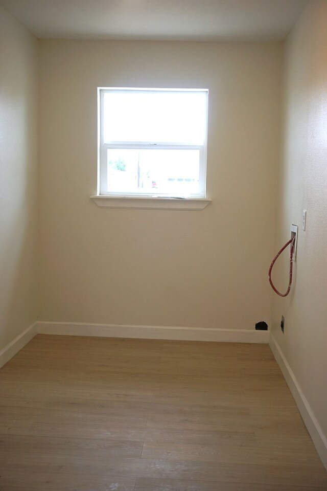 unfurnished room with light hardwood / wood-style floors and a healthy amount of sunlight