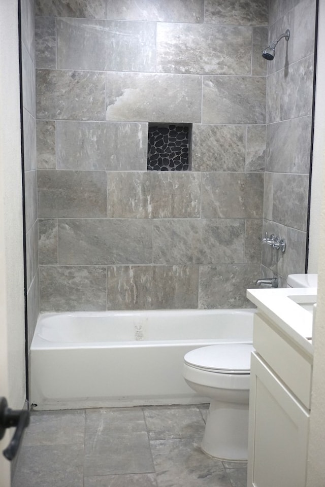 full bathroom with vanity, toilet, and tiled shower / bath