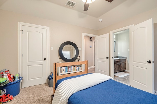 bedroom with ceiling fan, ensuite bathroom, and light carpet