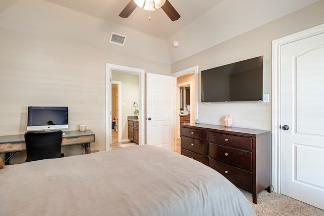 bedroom featuring ceiling fan, light colored carpet, ensuite bathroom, and lofted ceiling