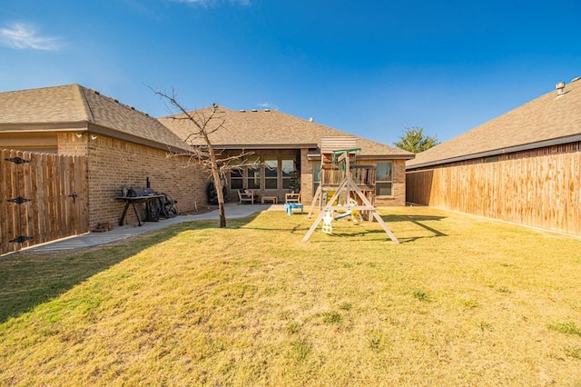 rear view of house featuring a lawn, a patio area, and a playground