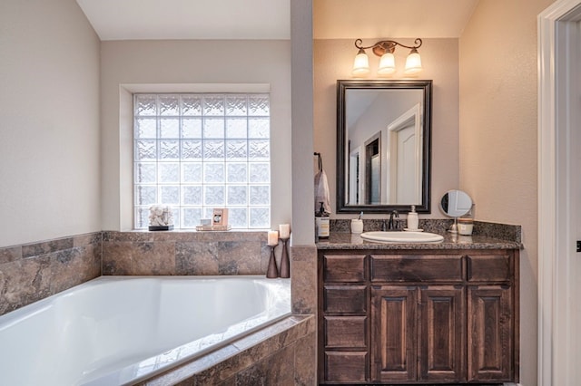 bathroom with vanity and a relaxing tiled tub