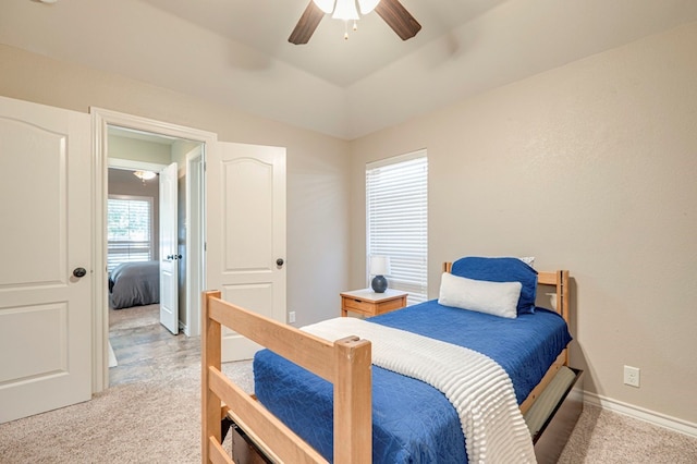 carpeted bedroom with multiple windows, ceiling fan, and lofted ceiling