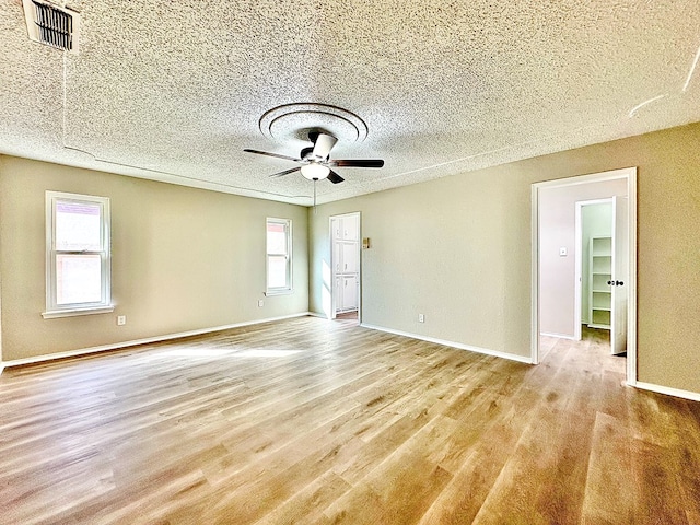 unfurnished room with a textured ceiling, light hardwood / wood-style flooring, and ceiling fan