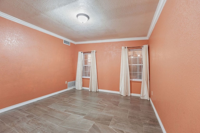 empty room with ornamental molding and a textured ceiling