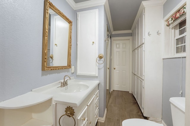 bathroom featuring vanity, toilet, and ornamental molding