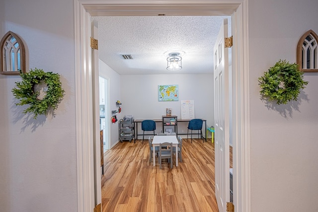 5004 Los Alamitos Dr, Midland, TX 79705 - dining space featuring light wood-style flooring and a textured ceiling