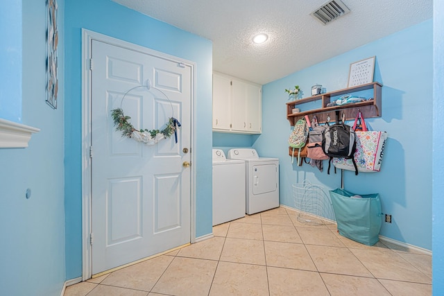 5004 Los Alamitos Dr, Midland, TX 79705 - washroom featuring cabinet space, separate washer and dryer, a textured ceiling, light tile patterned flooring, and baseboards