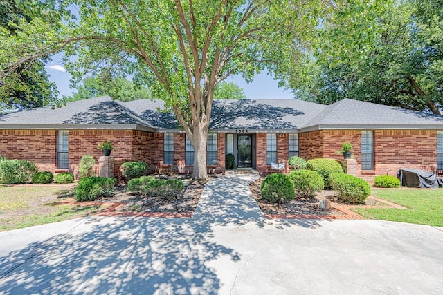 5004 Los Alamitos Dr, Midland, TX 79705 - ranch-style home featuring brick siding and a shingled roof
