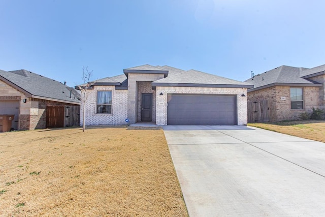 view of front of property with driveway, a front lawn, fence, an attached garage, and brick siding