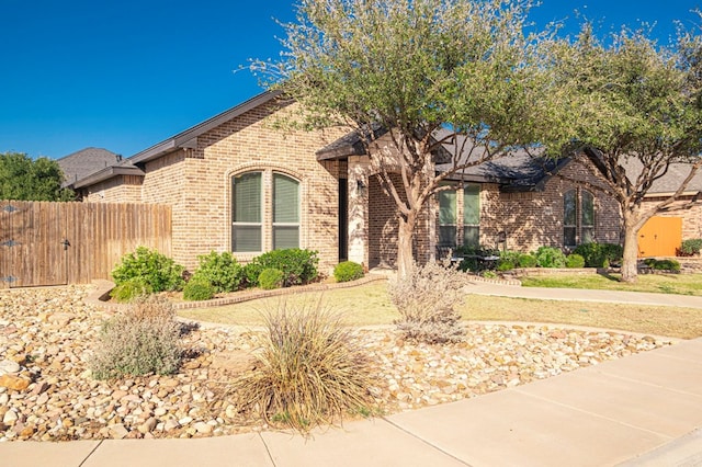 view of front of property with brick siding and fence