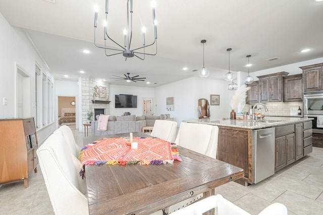 dining area with visible vents, a stone fireplace, a ceiling fan, and recessed lighting