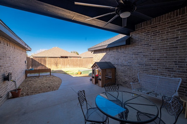 view of patio with outdoor dining area, a fenced backyard, and ceiling fan