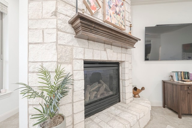 room details featuring ornamental molding, a fireplace, and baseboards