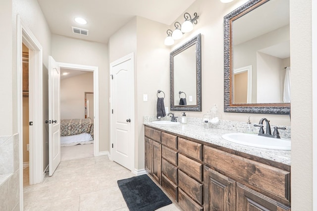 full bath with connected bathroom, visible vents, a sink, and double vanity