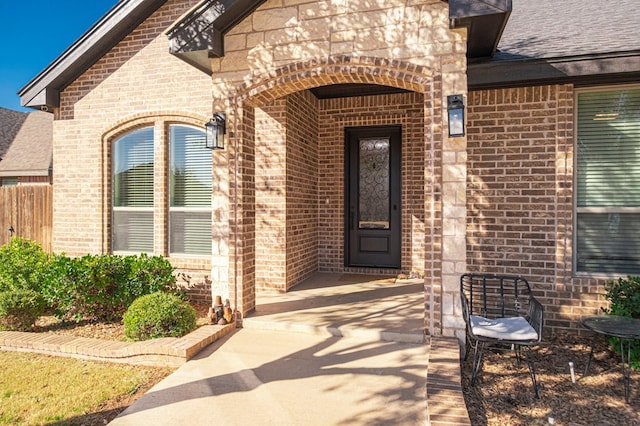 property entrance with brick siding and a shingled roof