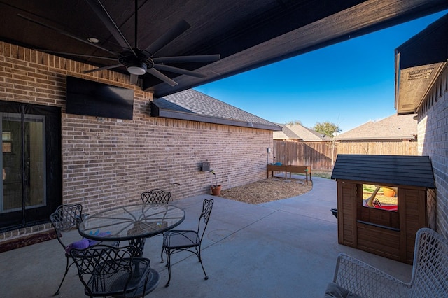 view of patio featuring a ceiling fan, outdoor dining area, and fence