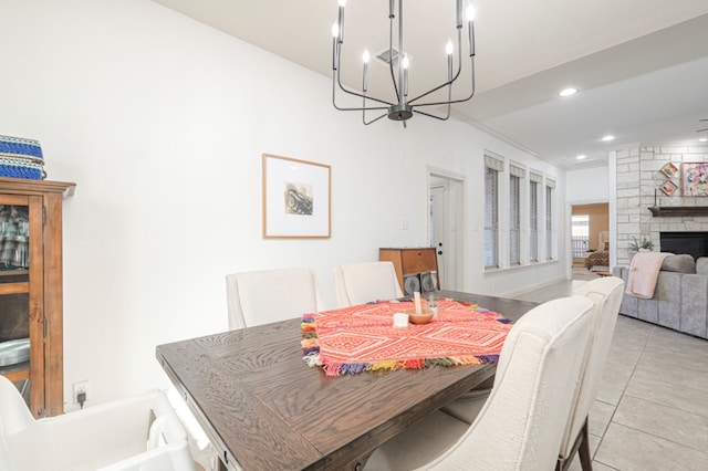 dining area featuring light tile patterned floors, a fireplace, a chandelier, and recessed lighting