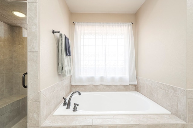 bathroom featuring a stall shower and a garden tub