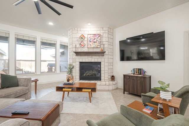 living area with baseboards, ceiling fan, crown molding, a fireplace, and recessed lighting