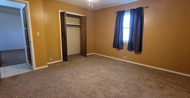 unfurnished bedroom featuring light carpet and a closet