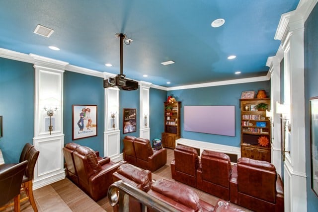 home theater with ornamental molding and decorative columns