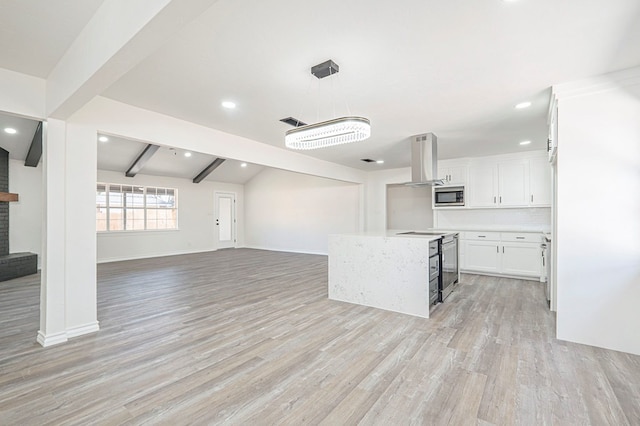 kitchen featuring visible vents, light wood-style flooring, stainless steel microwave, open floor plan, and island exhaust hood