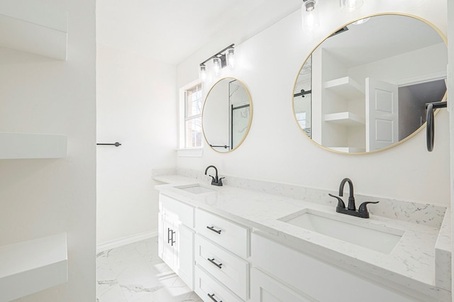 full bathroom with double vanity, marble finish floor, baseboards, and a sink