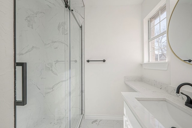 full bath with marble finish floor, baseboards, vanity, and a marble finish shower