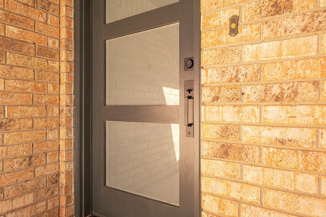 doorway to property featuring brick siding