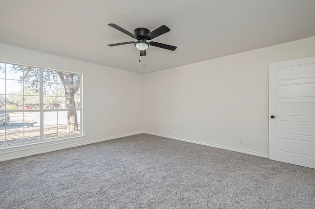 spare room featuring a ceiling fan, carpet, and baseboards