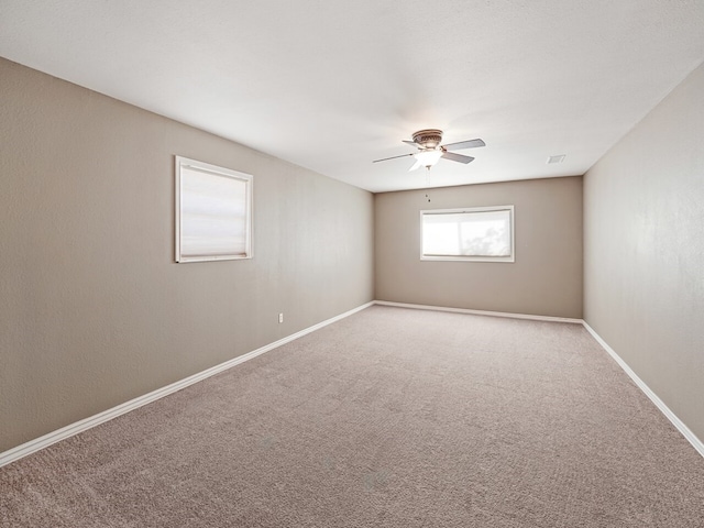 carpeted spare room with ceiling fan