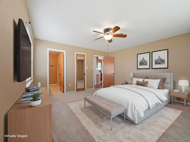 carpeted bedroom featuring ceiling fan and ensuite bath