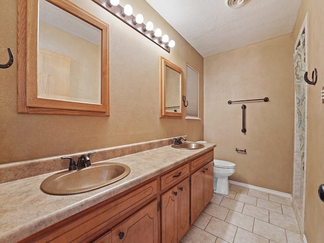 bathroom featuring vanity, toilet, tile patterned flooring, and a textured ceiling