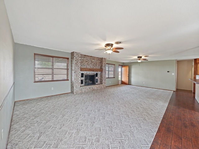 unfurnished living room with hardwood / wood-style floors, a fireplace, and ceiling fan