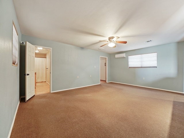 unfurnished bedroom featuring ceiling fan, ensuite bathroom, carpet floors, and an AC wall unit