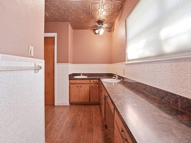 kitchen featuring tile walls, sink, hardwood / wood-style flooring, and ceiling fan