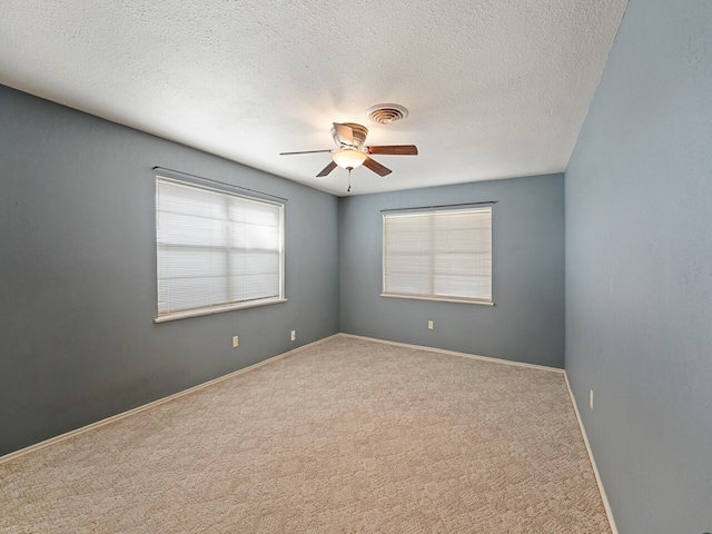 spare room featuring carpet floors, a textured ceiling, and ceiling fan