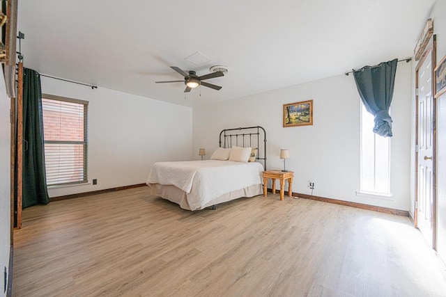 bedroom featuring multiple windows, light hardwood / wood-style floors, and ceiling fan